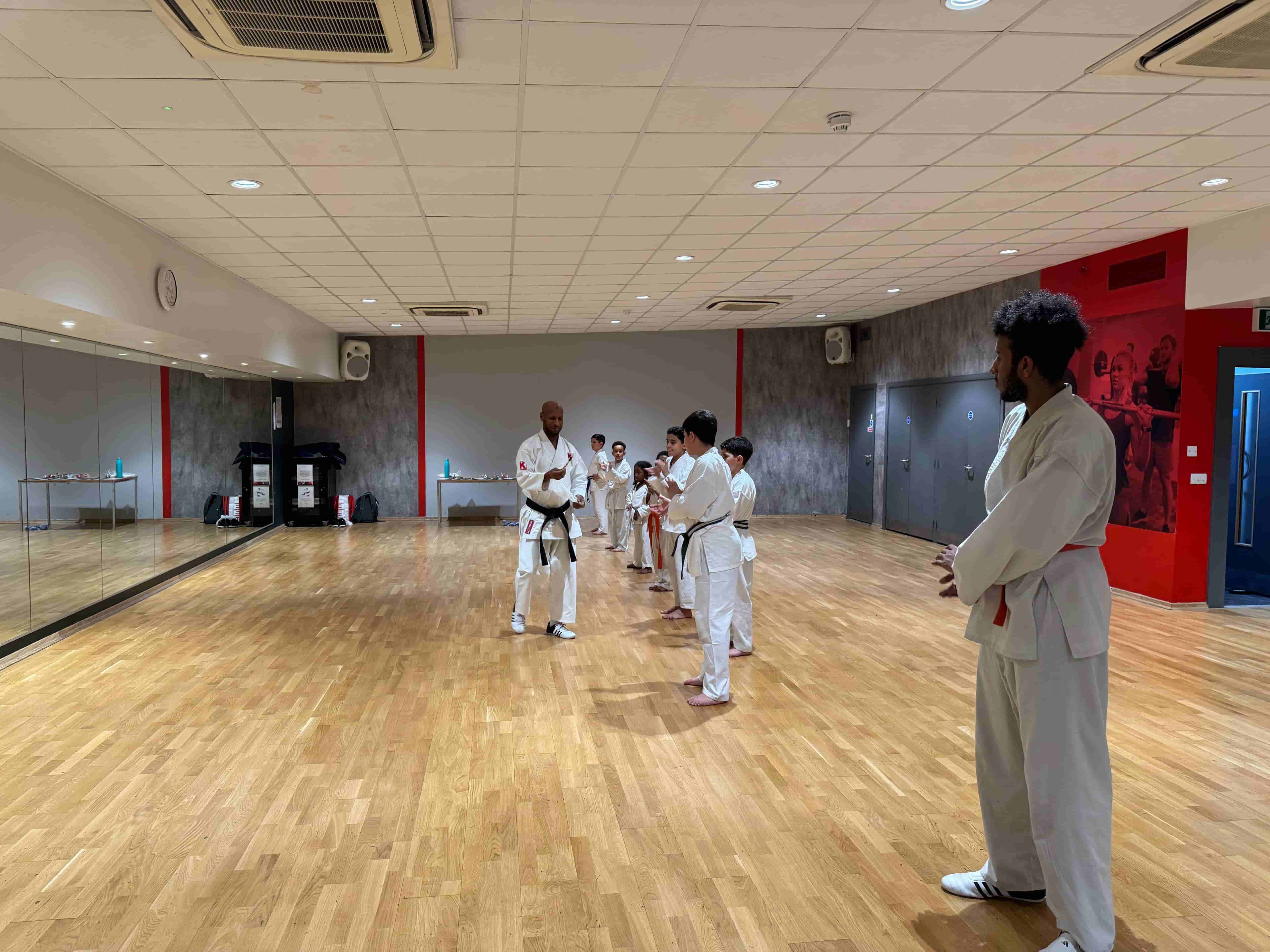 Students practicing Shotokan karate blocks in London dojo
