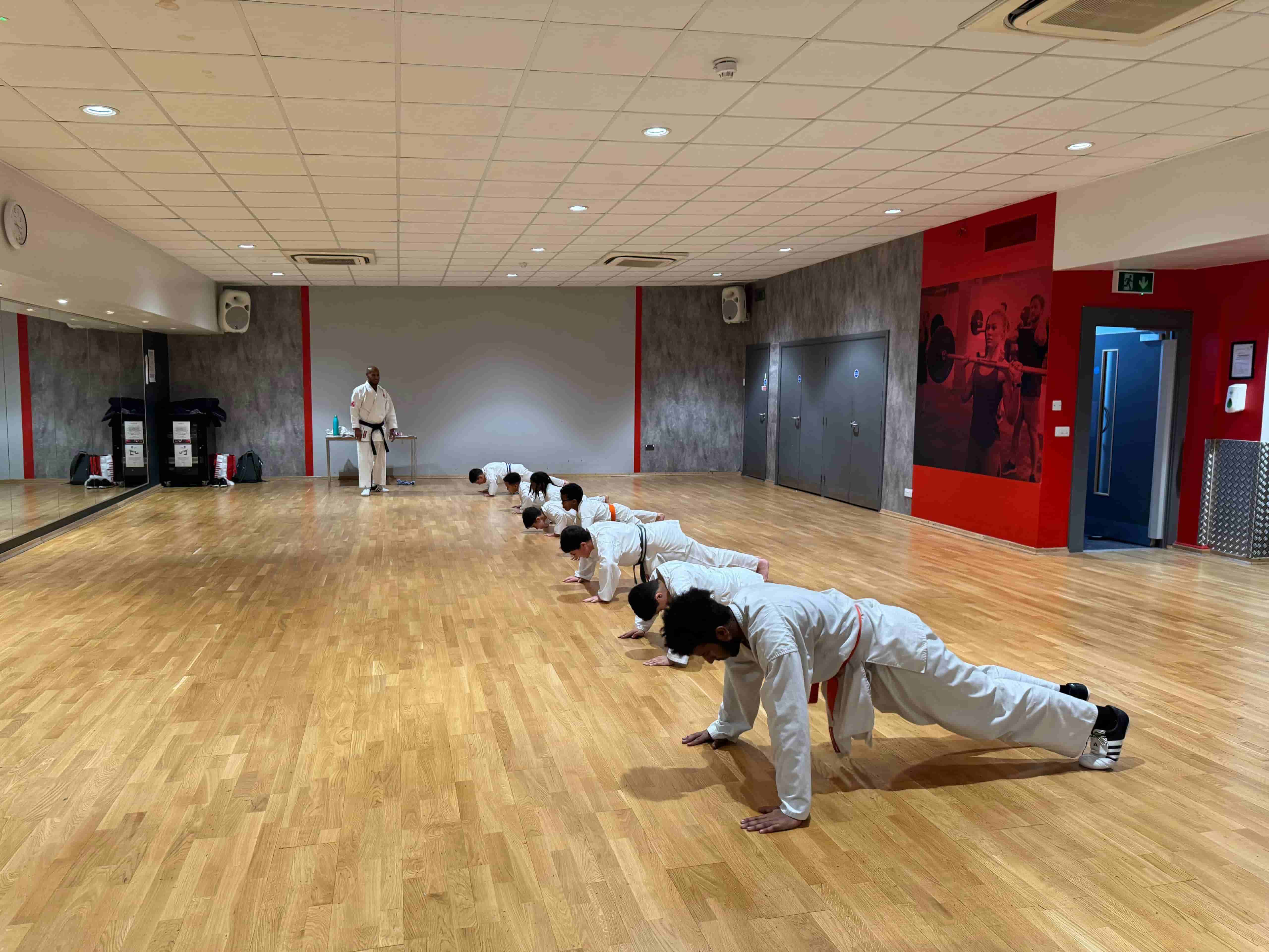 Students practicing Shotokan karate blocks in London dojo