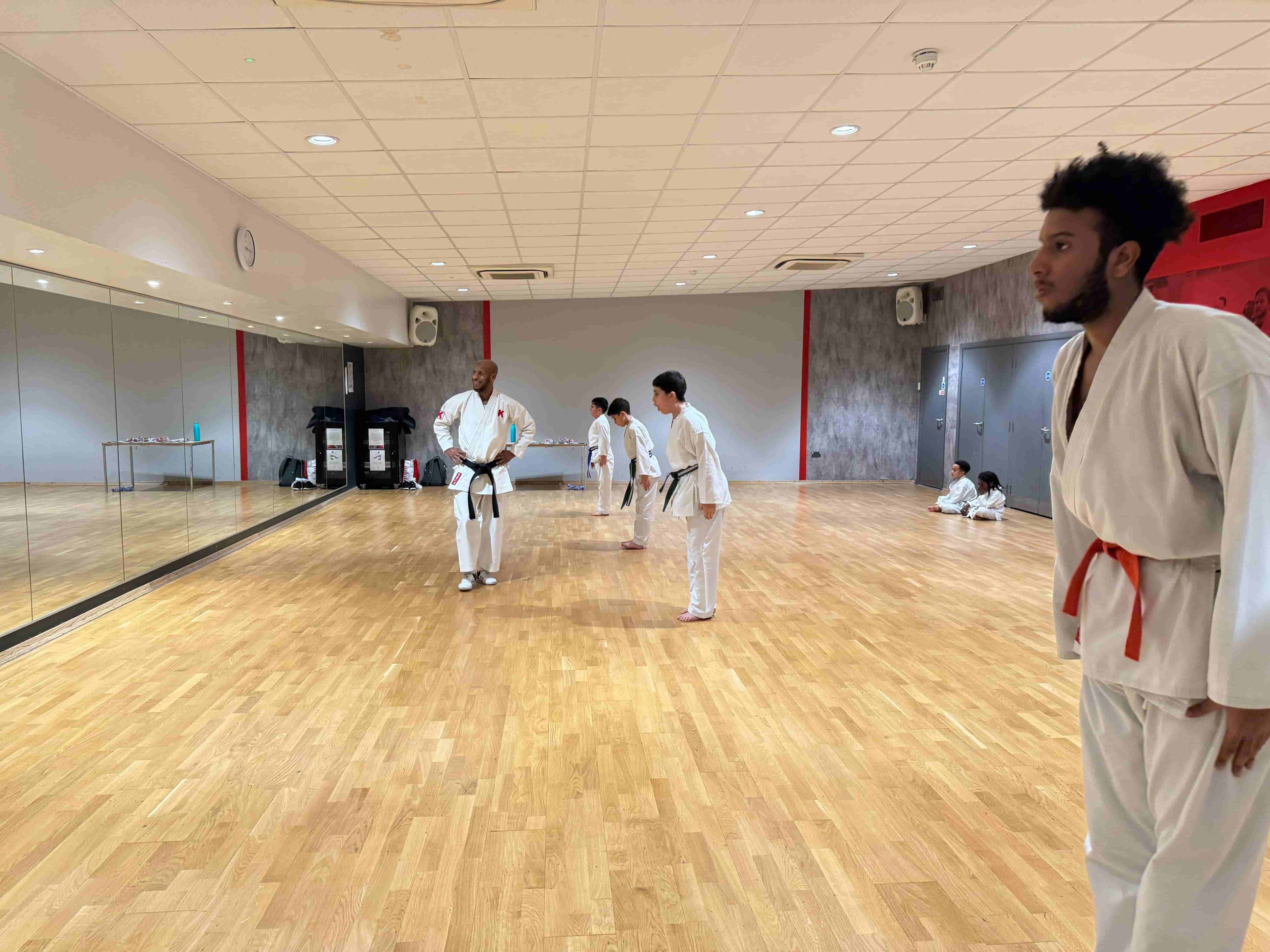Students practicing Shotokan karate blocks in London dojo